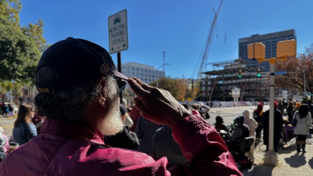 Dwight Tillman salutes as the "Star-Spangled Banner" is sung in the distance. Tillman was unable to speak because of a recent illness, but he came out to "show support to everyone."