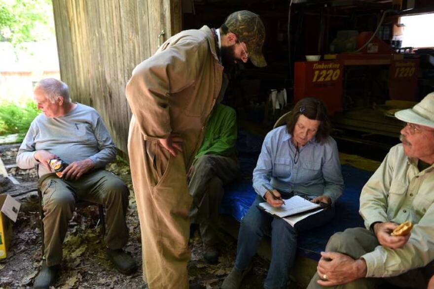 Ethan Kilham checks in with Debbie Kilham about the yearling bears that have been tranquilized so far at the Kilham Bear Center in Lyme, N.H. on Thursday, June 1, 2023. Ethan Kilham is the caretaker for the bears at the center. Ben Kilhem, left, has been rescuing bears in Lyme since 1993. Walt Cottrell, a wildlife veterinarian, is having a quick lunch on the right. (Valley News - Jennifer Hauck) Copyright Valley News. May not be reprinted or used online without permission. Send requests to permission@vnews.com.