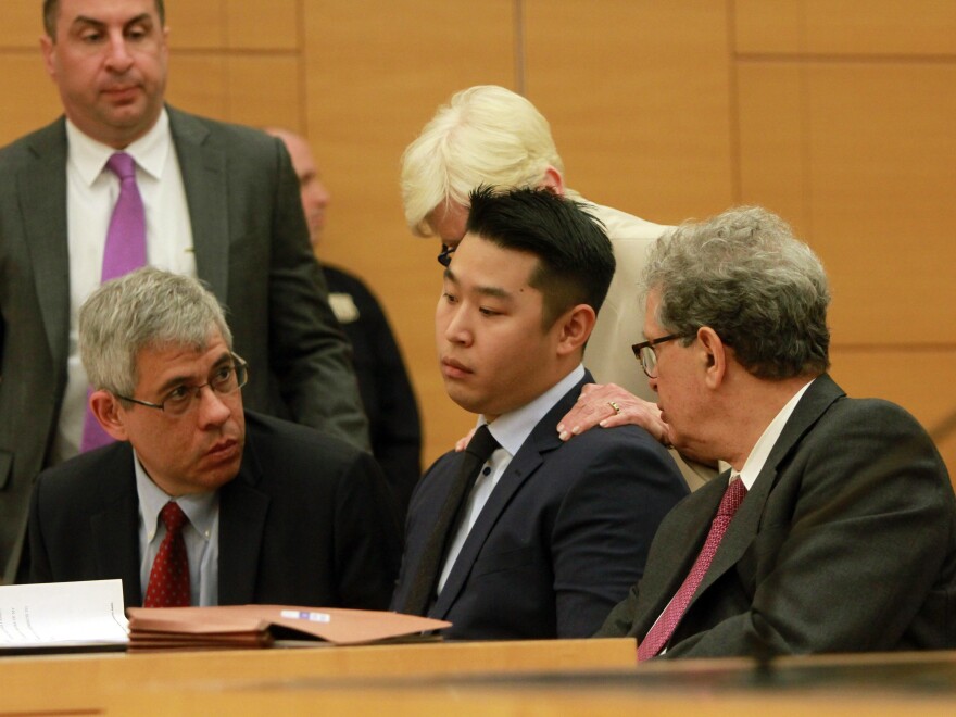 Peter Liang sits with his attorneys for his sentencing at Kings County Supreme Court in Brooklyn, N.Y.