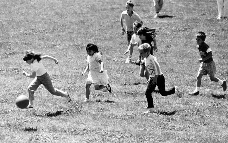 A photo from 1990 of children from Our Lady's Montessori School playing soccer in Gillham Park.