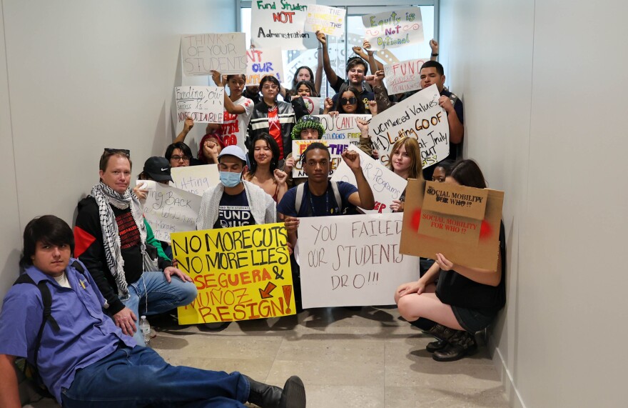 Students stand in front of a door blocking the Chancellor's office in the Administration building.
