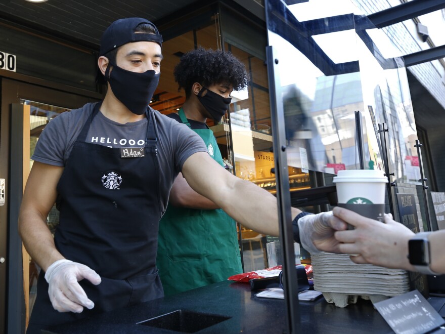 A Starbucks shift supervisor serves a customer on May 21 in Sacramento, Calif. Over 50,000 current and former Starbucks employees have used Coworker.org.