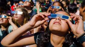 Pupils, wearing protective glasses, look at the partial solar eclipse in Schiedam, Netherlands, on June 10, 2021. (Marco de Swart/AFP via Getty Images)