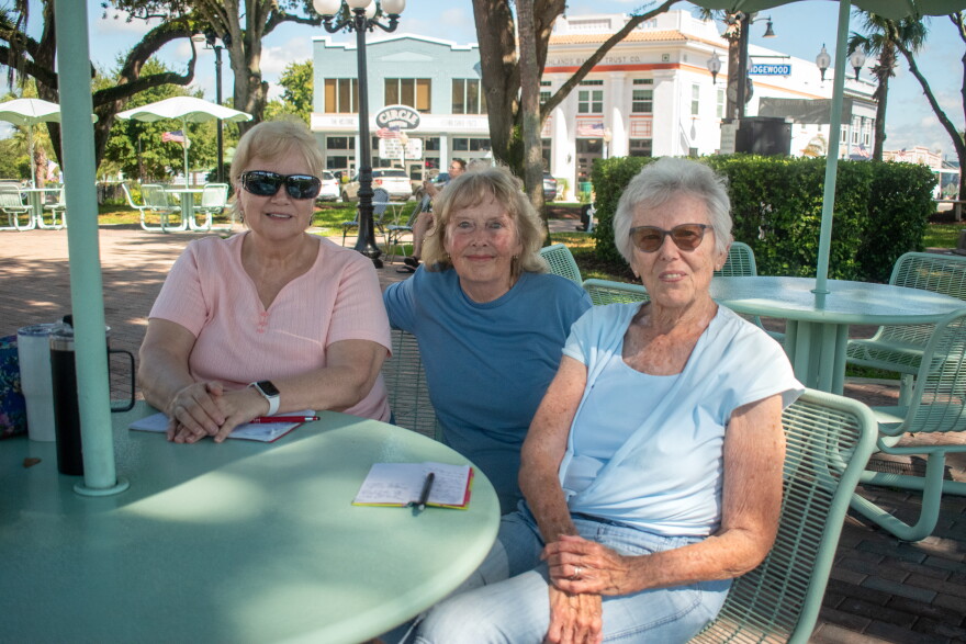 Neina Ryan, left, and Marsha Nowels, right, pose with their friend Pam during their weekly prayer group on Wednesday, Sept. 9, 2026, in Circle Park in downtown Sebring.