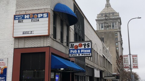 Signs for Hoops Pub & Pizza are mounted on the side exterior wall and above the entryway at 516 Main Street in downtown Peoria. 