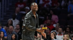 Miami Heat legend Dwyane Wade walks on the court during a time out while watching an NBA basketball game between the Miami Heat and the Dallas Mavericks, Monday, Oct. 26, 2026, in Miami.