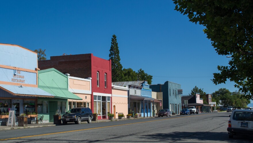 A row of old 1800's buildings along a street, all different colors