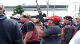 A man carries a rifle during a counter protest in Bethel on Sunday.