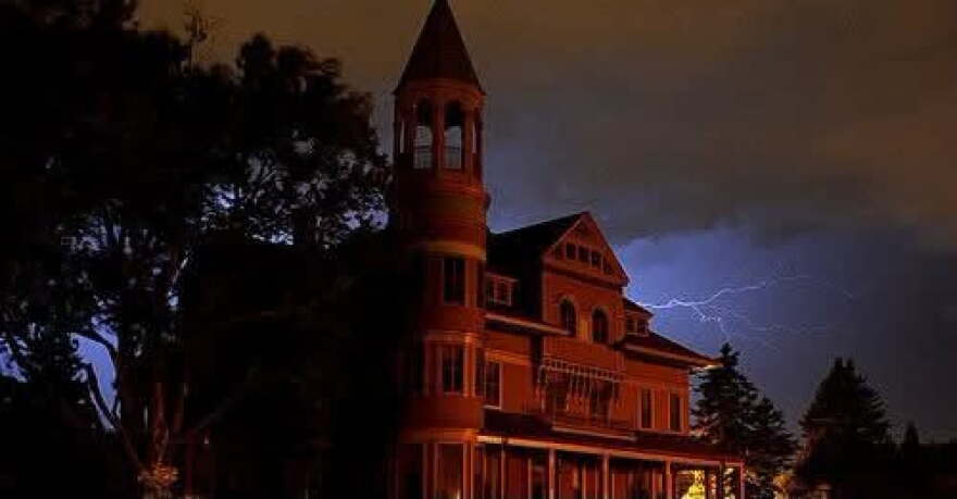 Mansion with a conical tower against a stormy night sky