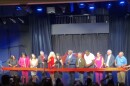 Winter Park and Orange County officials assist Winter Park Playhouse Executive Director Heather Alexander (center, in red dress) in cutting the ribbon onstage at Winter Park Playhouse on Tuesday, July 7, 2026.