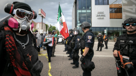 Protesters inch closer to a line of police officers on South Broadway, standing between them and on-ramps to Interstate 25. June 10, 2025.