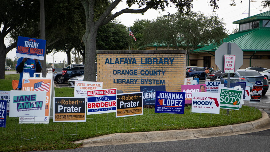 Campaign signs crowd the grass at the Alafaya Library parking lot in Orange County on Monday, Oct. 19, 2026. More voters cast ballots early in person at the library on Monday than at any other early voting location in Orange County.