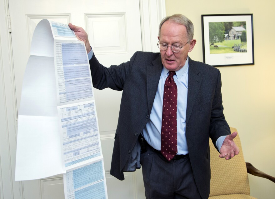 Sen. Lamar Alexander, R-Tenn., holds the Free Application for Federal Student Aid, or FAFSA. Alexander is pushing to shorten the 108-question form to just two questions.