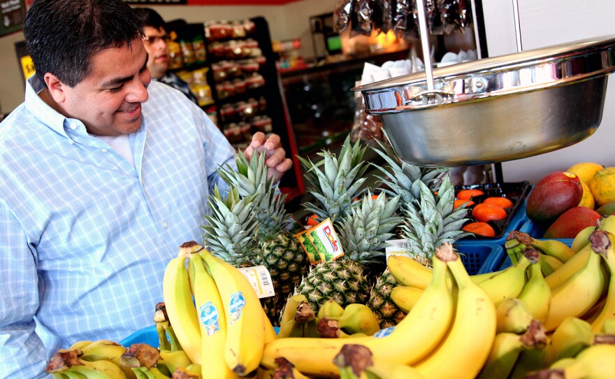 Alex Ortega, a professor of public health at UCLA, looks over the produce at the market he and other community members helped reopen.
