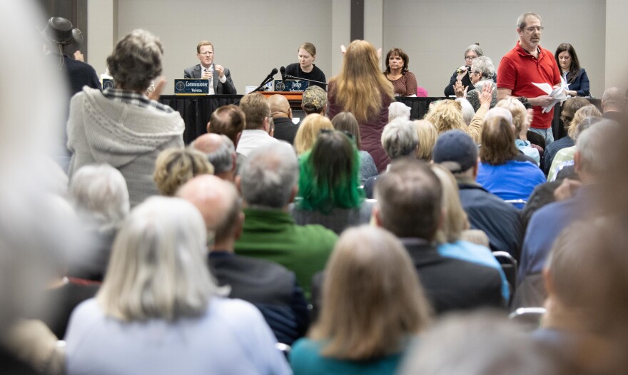 Doug Hartman takes his seat after comments on Thursday. The subsequent applause prompted instructions that there be no clapping, which were not heeded by attendees.