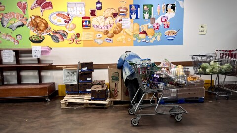 Ann selects a watermelon from the Capuchin Soup Kitchen food pantry amidst uncertainty around SNAP benefits due the federal government shutdown. We're identifying only by her first name, Ann, to protect her family's privacy.