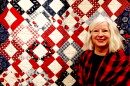 Quilter Laurie Wichryk Wilson poses with her quilt that was recovered from Big Horse Creek after Helene. PAUL GARBER/WFDD
