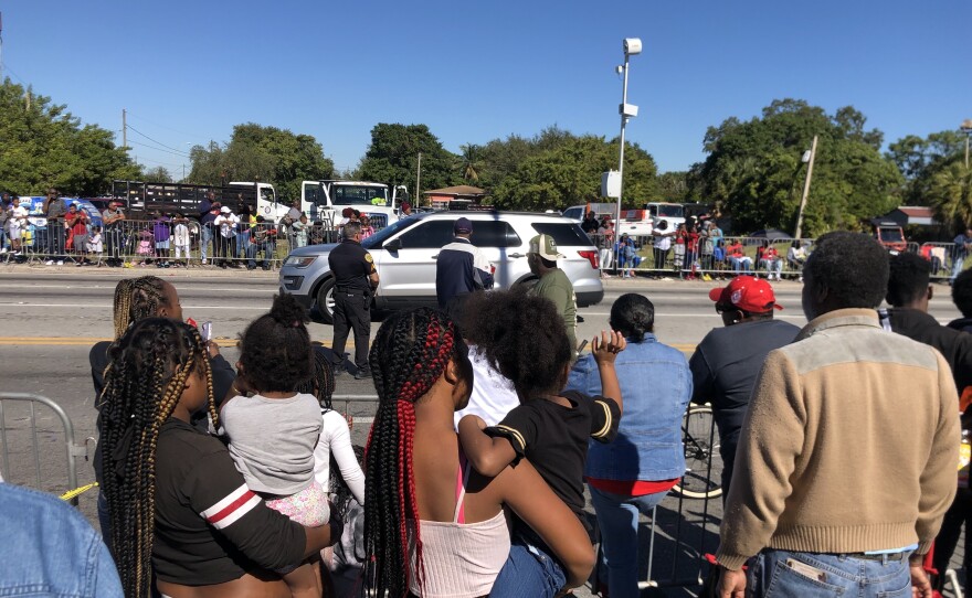 A child waves as the MLK Day parade rolls by in Liberty City. Event organizers say the route retraces some of Dr. King's travels from when he visited Miami.