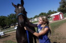 Cady Stortzum looks after her horse E.L.'s Legacy at the Eureka Downs horse racing track. She will race four horses at the re-opened track this month.
