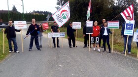 About 20 people wave anti-immigrant placards and flags at a Jobbik rally last Tuesday in Szentgotthárd, a rural factory town near Hungary's border with Austria.