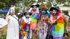 A group of colorful, bearded drag performers pose for a group photo.
