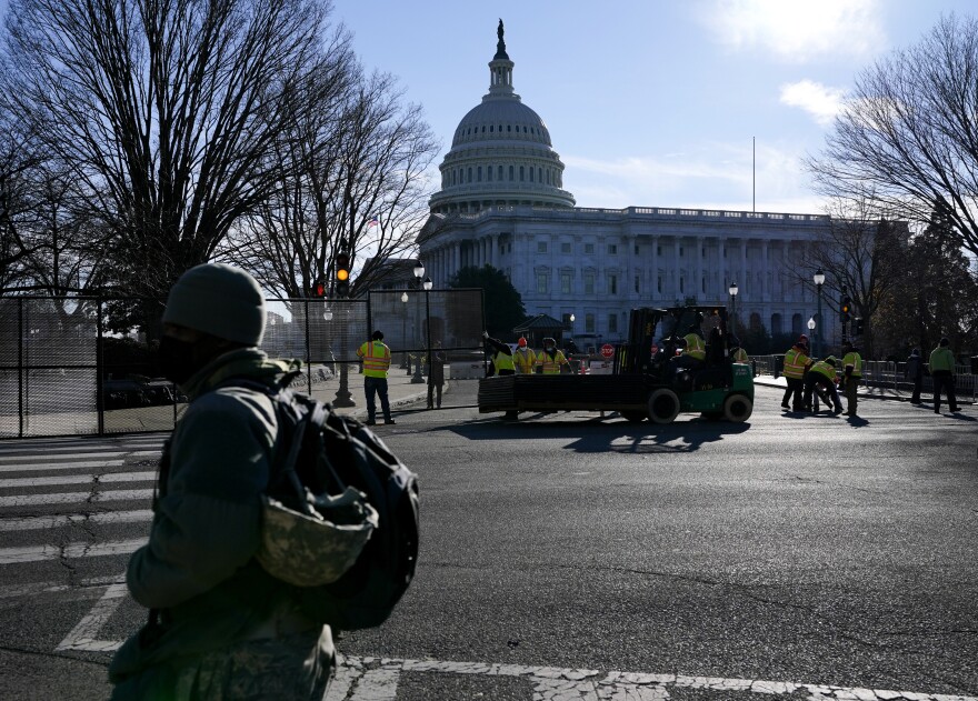 With the U.S. Capitol in the background, workers install fencing around the Capitol grounds the day after violent protesters loyal to President Donald Trump stormed the U.S. Congress in Washington, Thursday, Jan. 7, 2021.