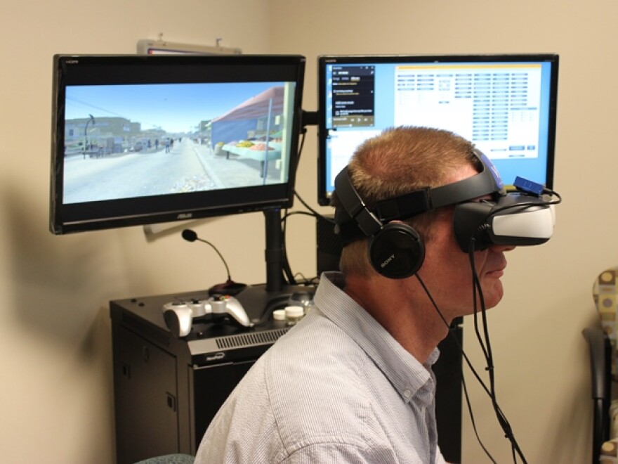 Therapist Keith Smith demonstrates virtual reality equipment at the University of Central Florida. Smith uses virtual reality to help treat veterans' post traumatic stress disorder.