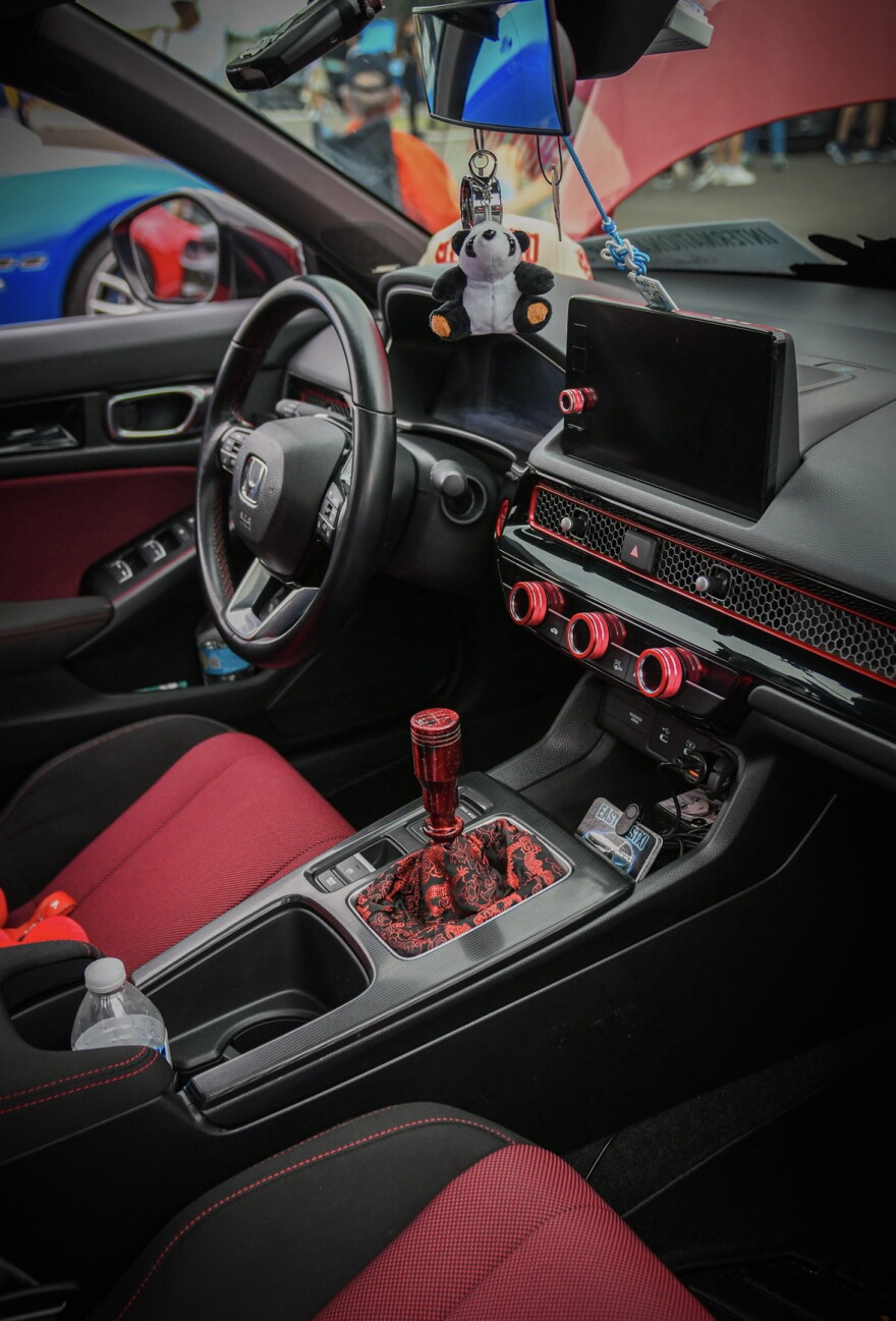 A customized Honda interior features red accents, a decorative gear shift and a hanging panda accessory at the sixth annual International Car Show in Gainesville, Florida, on Saturday, Oct. 17, 2026. (Courtesy of Harris Marcus)