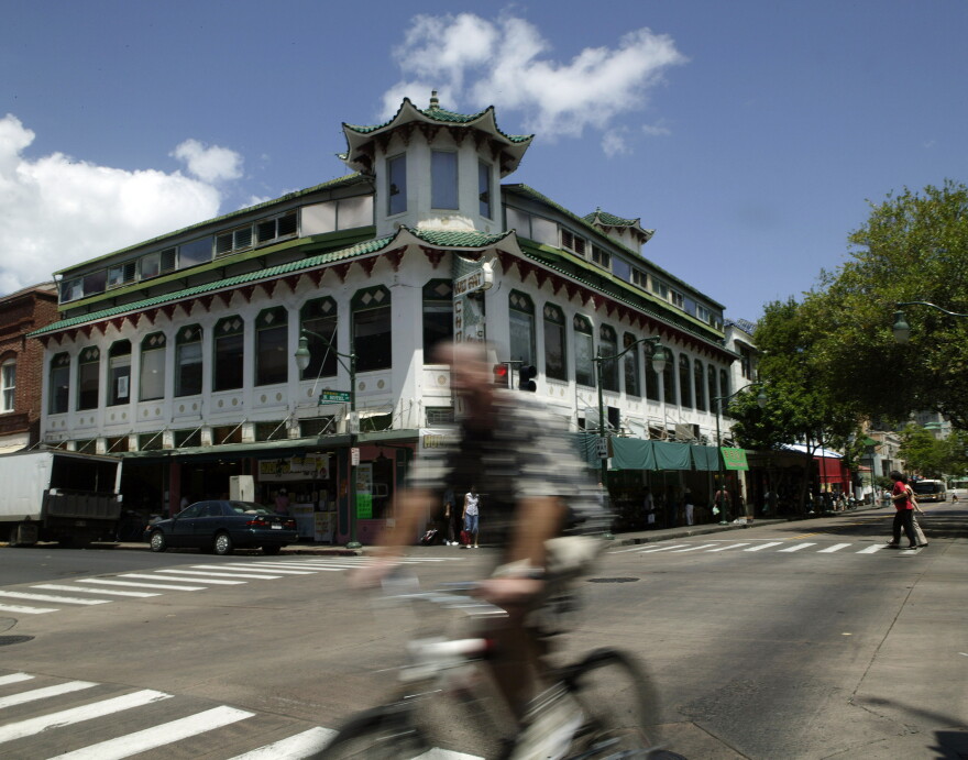 In this May 17, 2007, file photo, a bicyclist rides past the Wo Fat building in Honolulu's Chinatown.