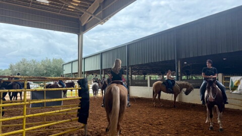 Competitors practice during exhibition runs at the PacWest Barrel Racing event. Riders pay $5 per turn to warm up their horses and familiarize them with the arena before competition.