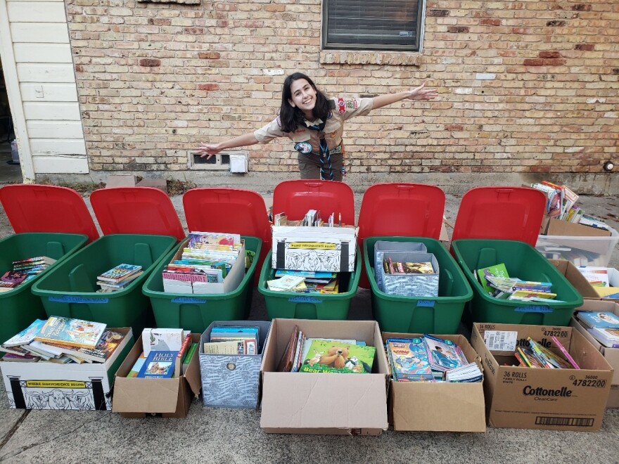 Madison Knefley stands behind tubs filled with hundreds of books she collected through a contactless book drive. The book drive was part of her eagle project, where she decided to create a community library at a public housing apartment complex in Highland Park. 