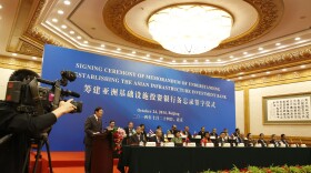 Chinese Finance Minister Lou Jiwei (left) speaks during the signing ceremony of the Asian Infrastructure Investment Bank last year in Beijing.