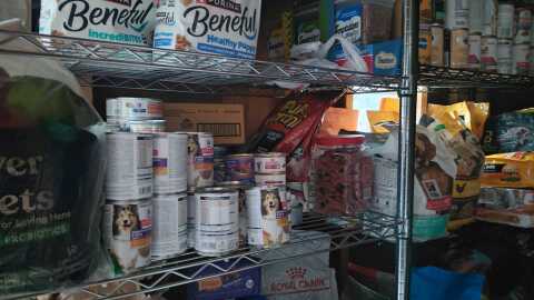 Shelves of cat and dog food are in a shed at the Dallas Humane Society. 