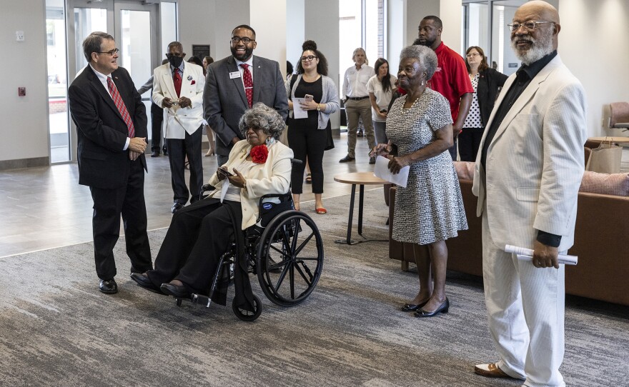 UGA President Jere Morehead stands with Kerry Rushin Miller, Mary Blackwell Diallo, and Harold A. Black as they look at paintings of themselves by artist Richard Wilson in the lobby of Black-Diallo-Miller Hall.