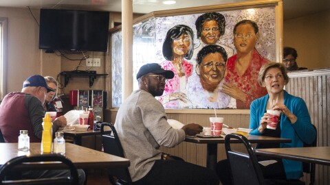 Democratic presidential candidate Sen. Elizabeth Warren, D-Mass., eats lunch with musician Benny Starr at Bertha's Kitchen on Friday in North Charleston, S.C.