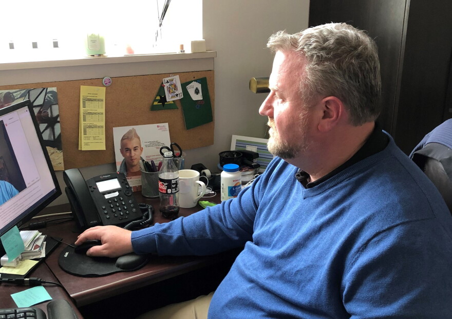 Dr. Craig Dietz, the chief medical office at KC Care Health Center, uses a computer to meet with a patient.