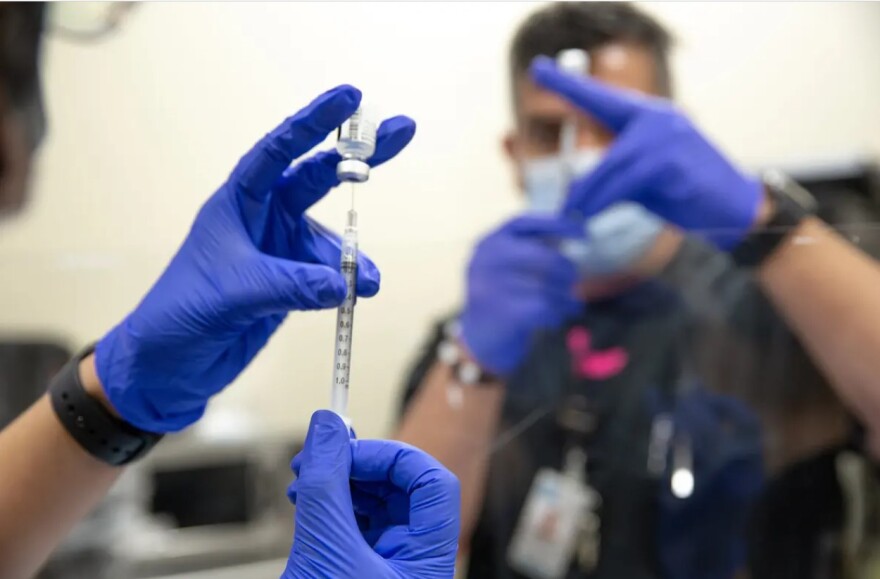 Doctors Hospital at Renaissance employees in Edinburg ready a Pfizer vaccine for administration on Dec. 19, 2020 .