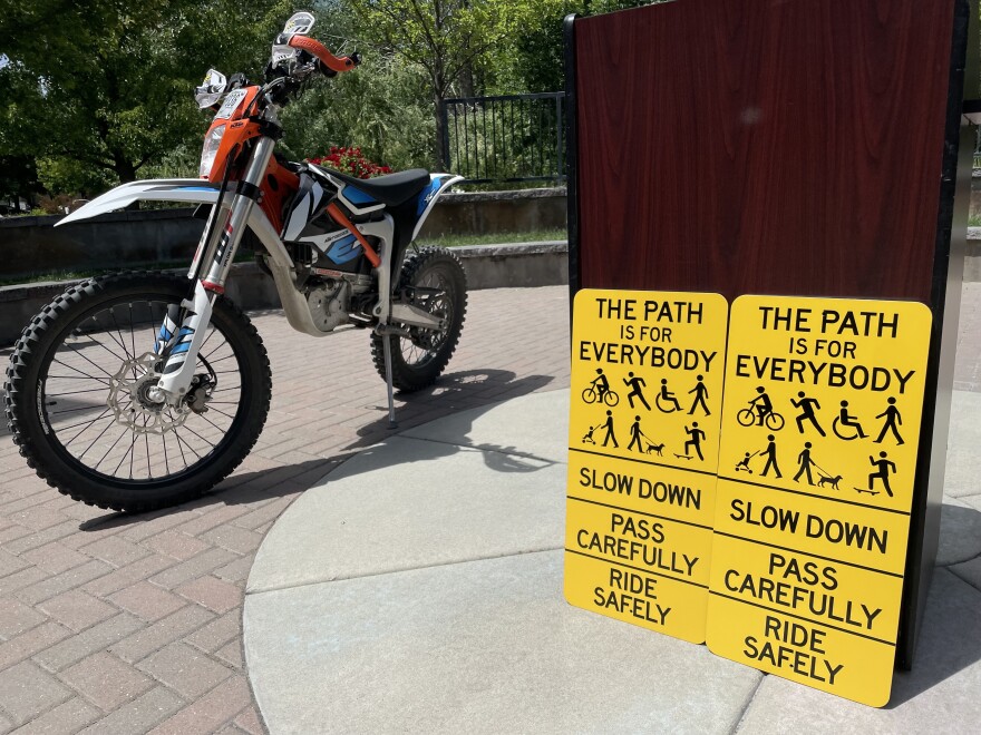 New signs on the Greenbelt will remind users to slow down and share the pathway. Some e-bikes, like the off-roading dirt bike pictured above, require permits and are not allowed on the Greenbelt.