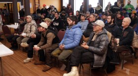 Mushers listen to rules and trail conditions for the Kuskokwim 300 Sled Dog Race in the Bethel Long House Hotel on January 19, 2017. Roger Lee is sitting in the front, right corner, taking notes.