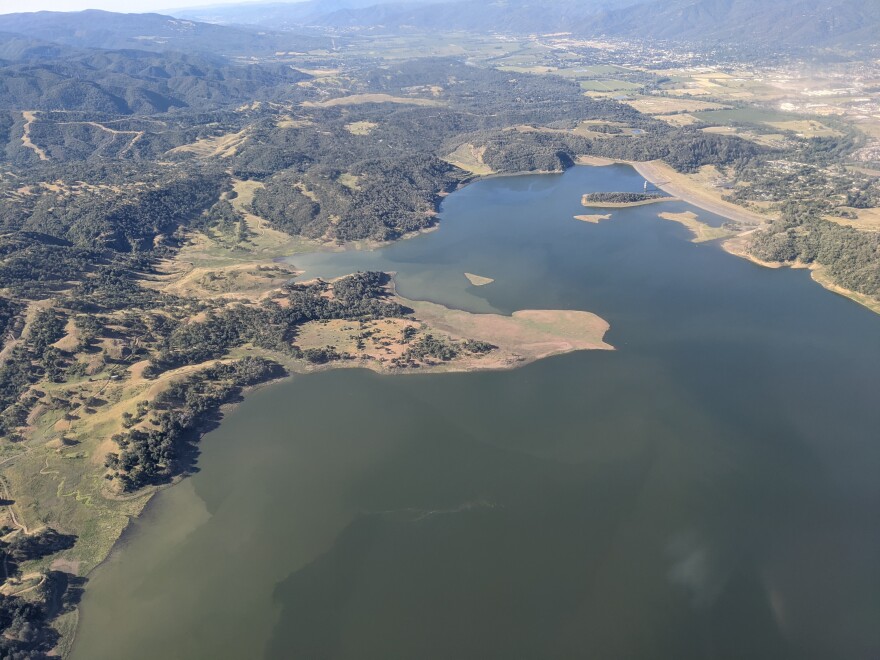 A lake surrounded by mountains and wilderness, seen from above.