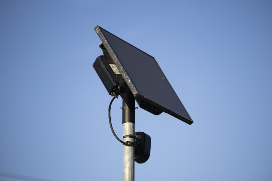 A Flock camera stands in a neighborhood on Koenig Lane in August. The surveillance tech firm has come under fire in recent weeks — and scores of cities, counties and police departments have opted out of using the license plate-reading cameras.