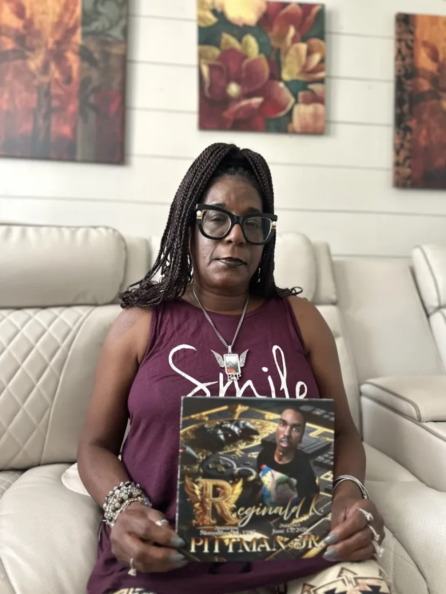 Robin Hamilton holds a photo of her son, Reginald Pittman.