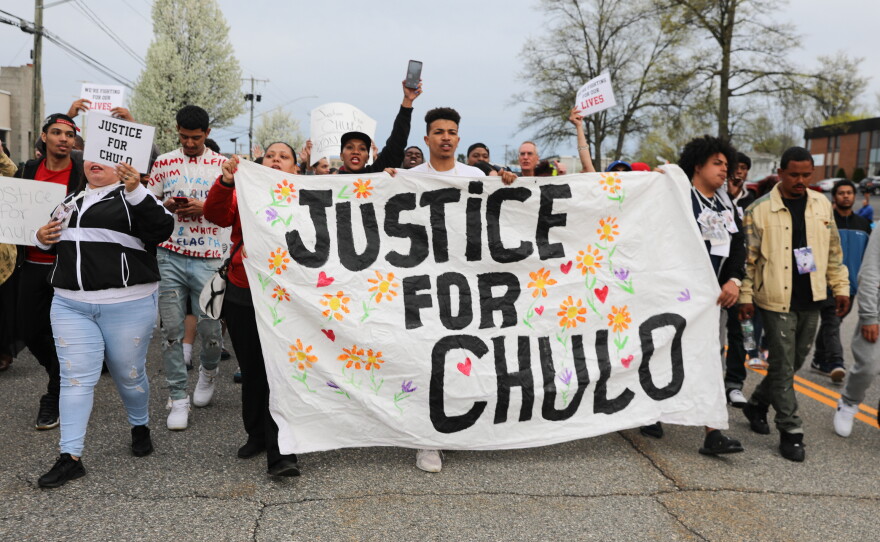 Kittrell Lauray, 18, center, a family friend, holds up a "Justice for Chulo" banner during Thursday's march down Silas Deane Highway in Wethersfield. Police blocked off the road for about two hours.