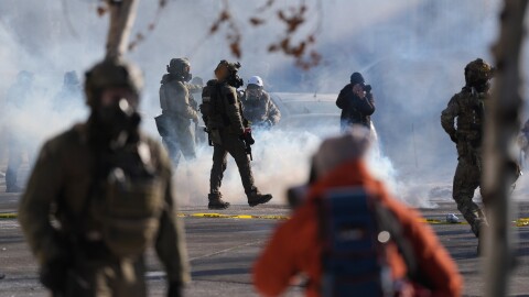 Federal immigration officers deploy tear gas at observers after a shooting Saturday, Jan. 24, 2026, in Minneapolis. (AP Photo/Abbie Parr)