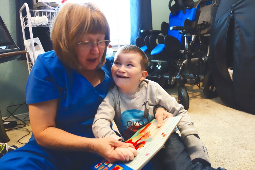 Home health nurse Rita Nuss reads a book to 9-year-old Josiah Melton, who has  chromosomal disorders and is on the developmental disabilities services waiting list.