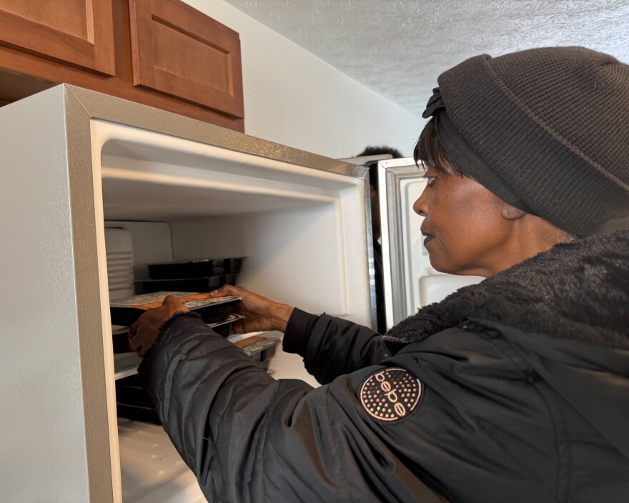 A chef from Miami Valley Meals places frozen meals into a Habitat for Humanity home freezer