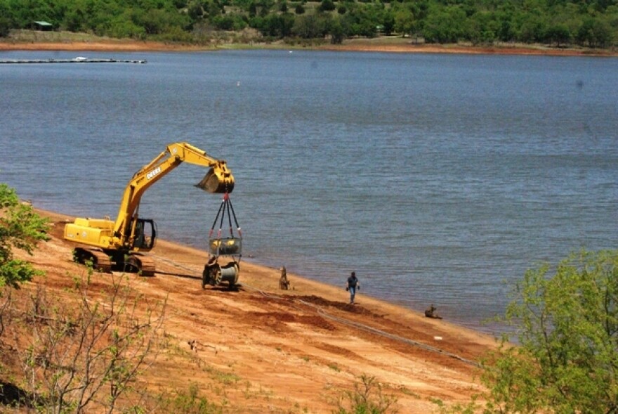 Heavy equipment is moved into a place to help fish a crane from Kaw Lake.