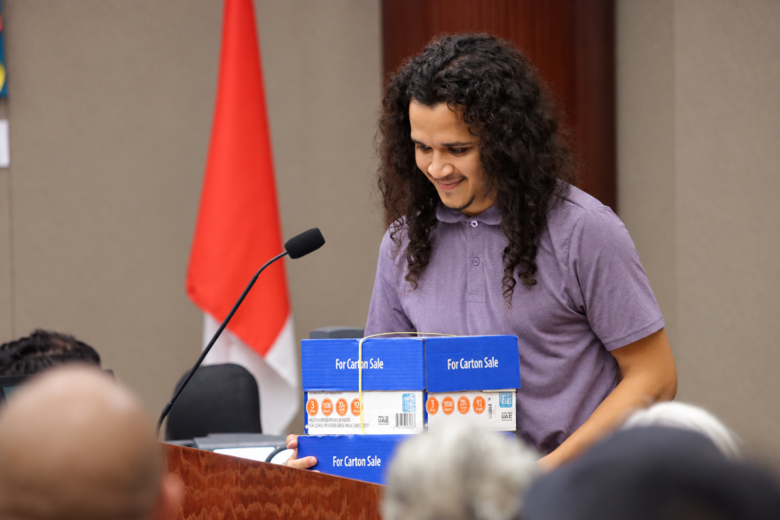 Ramon Pereira Bonilla, part of the Sunrise Movement Group, holds three boxes containing 3,000 signatures of Orange County residents in support of the Sunshine Transit Advancement Resolution -- or STAR -- plan, which would start with bus rapid transit and include light rail and heavy rail. Pereira Bonilla presented the signatures during the public comment section of Tuesday's Orange County Board of Commissioners meeting.
