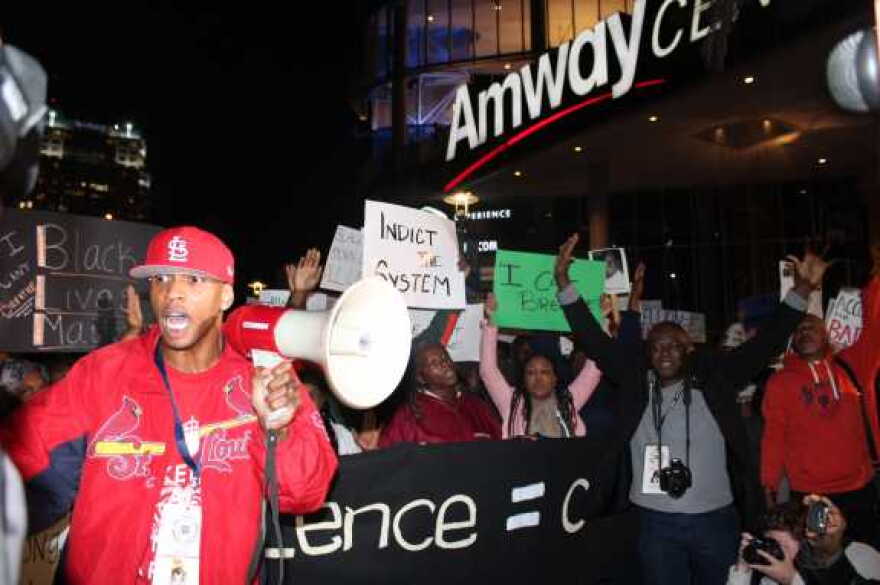 Protesters gathered in front of the Amway Center and staged a "die-in," where they lay on the ground holding signs of black men who were killed by police. Photo: Renata Sago, WMFE.