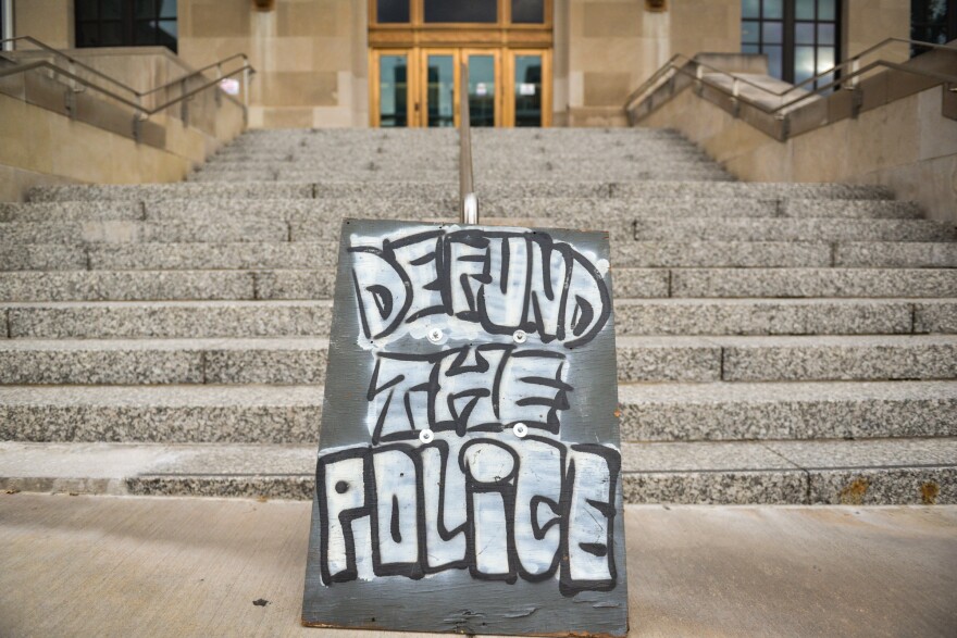 Demonstrators at Kansas City Police Headquarters used a large plywood sign to express their overriding sentiment during a protest Wednesday evening.